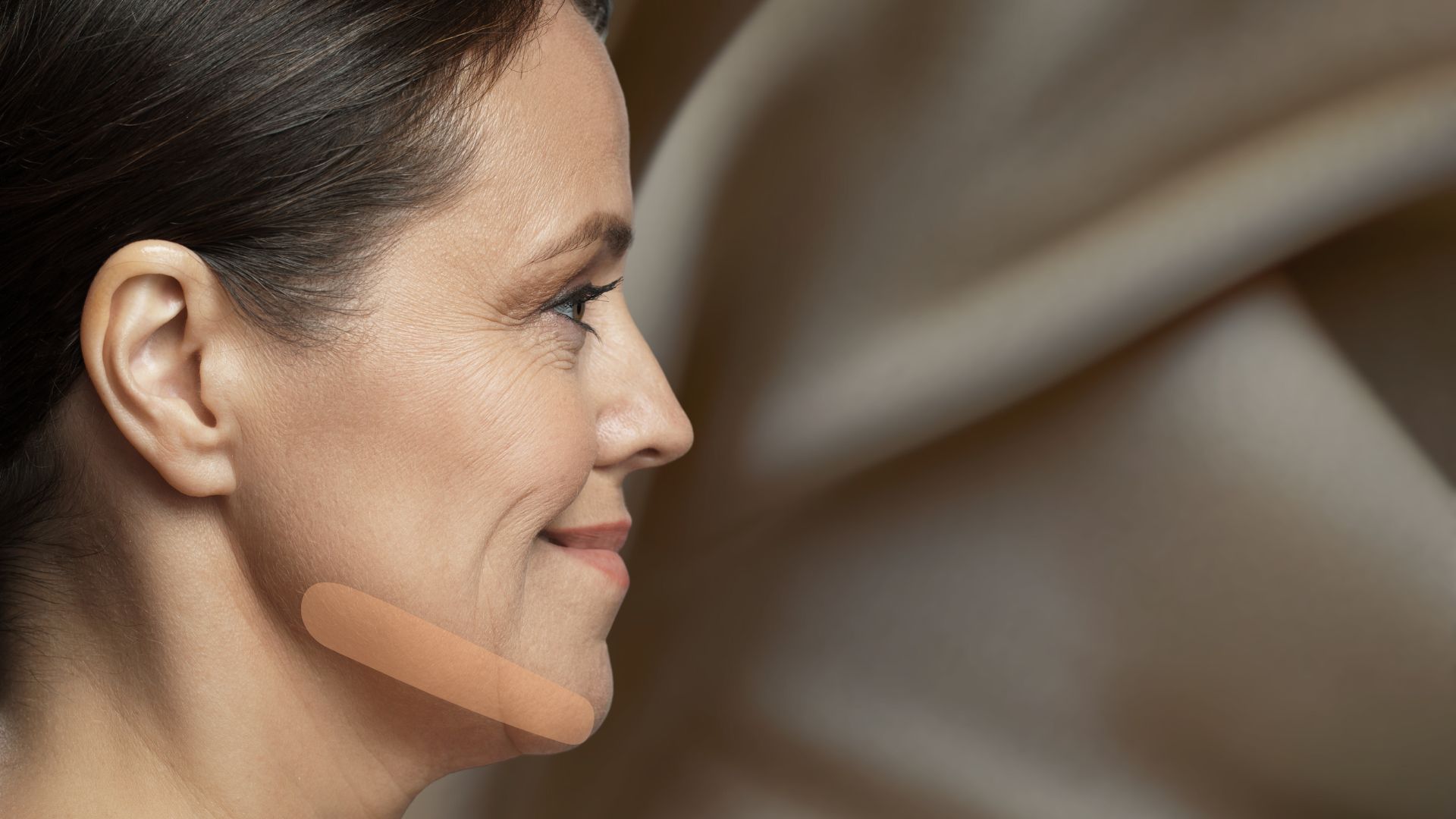 Das Gesicht einer Frau, besonders hervorgehoben wird die Kieferpartie. 