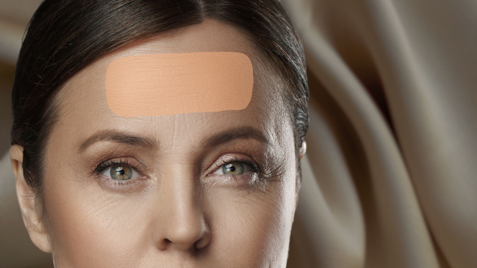 Das Gesicht einer Frau, besonders hervorgehoben wird die Stirn. 